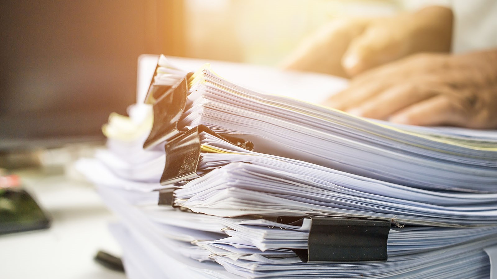 Businessman hands searching information in Stack of papers files