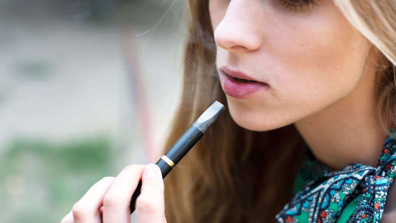 Woman smoking electronic cigarette outdoor