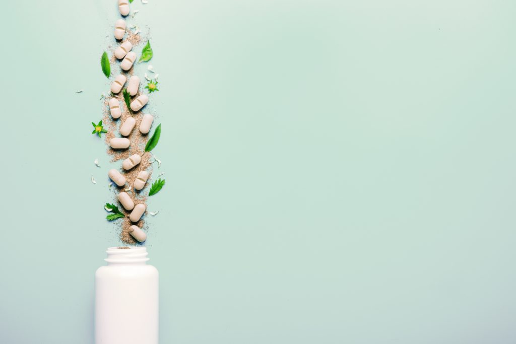 Natural herbal additives from herbs, poured from a white jar. The concept of healthy eating. Detox