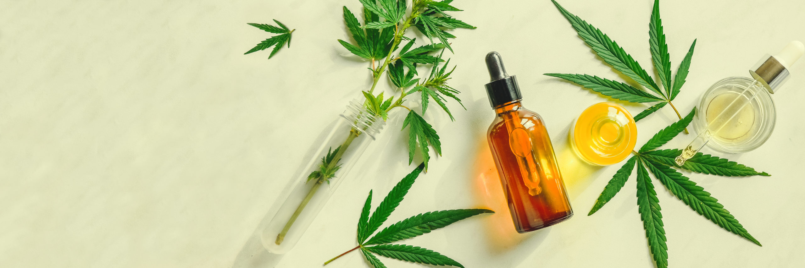 Various glass bottles with CBD oil, THC tincture and hemp leaves on a marble background. Flat lay, minimalism. Cosmetics CBD oil.