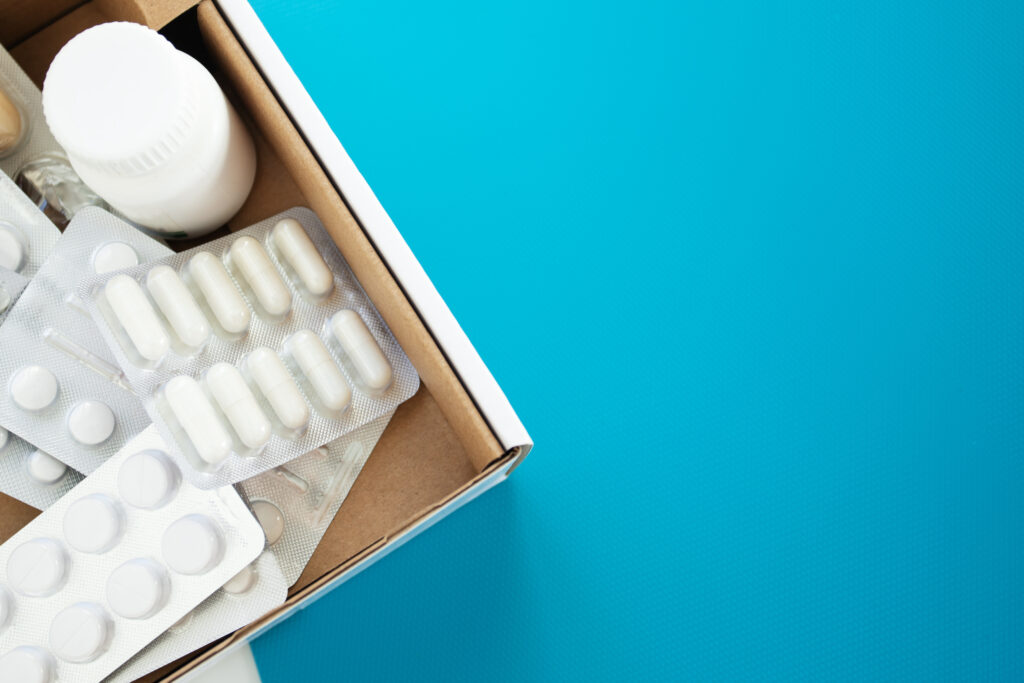 drugstore online, medicine box on blue background with copy space