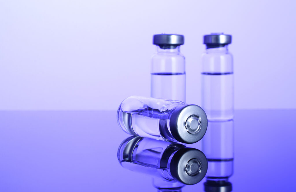 Clinical Trial – Vaccine: Covid-19, Coronavirus in vial with syringe on blue background