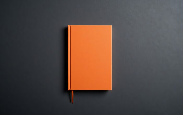 Orange book with ribbon on gray surface