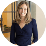 Auchincloss, Kalah_round Headshot of a smiling woman with long blonde hair wearing a black blazer and black shirt.